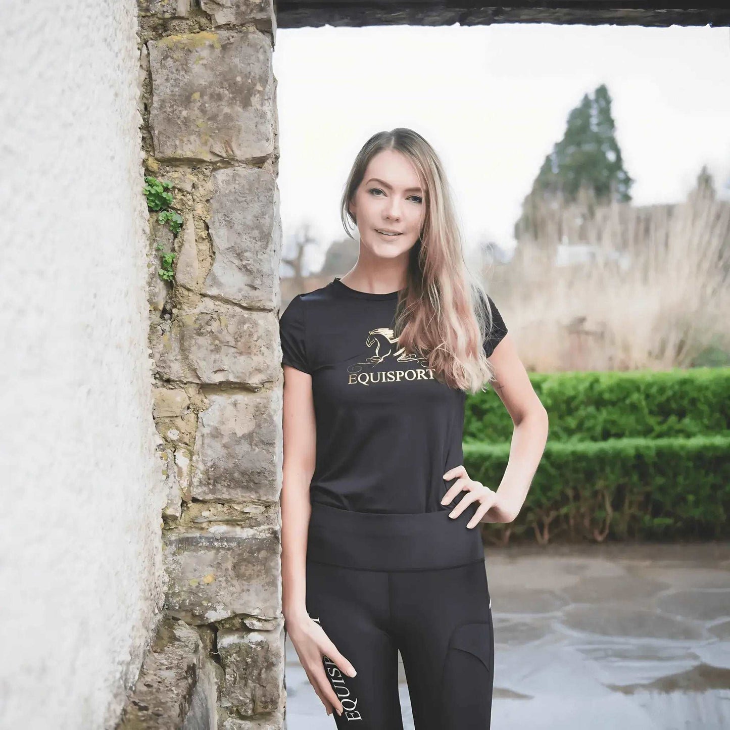 Equestrian Sports T-Shirt by Equisport color black alongside with wall